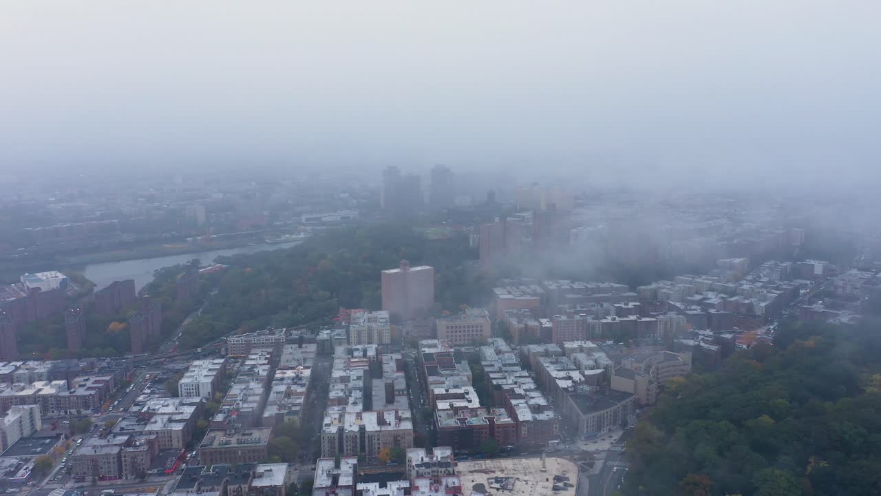 slow aerial trucking tilt down through fog in uptown New York City