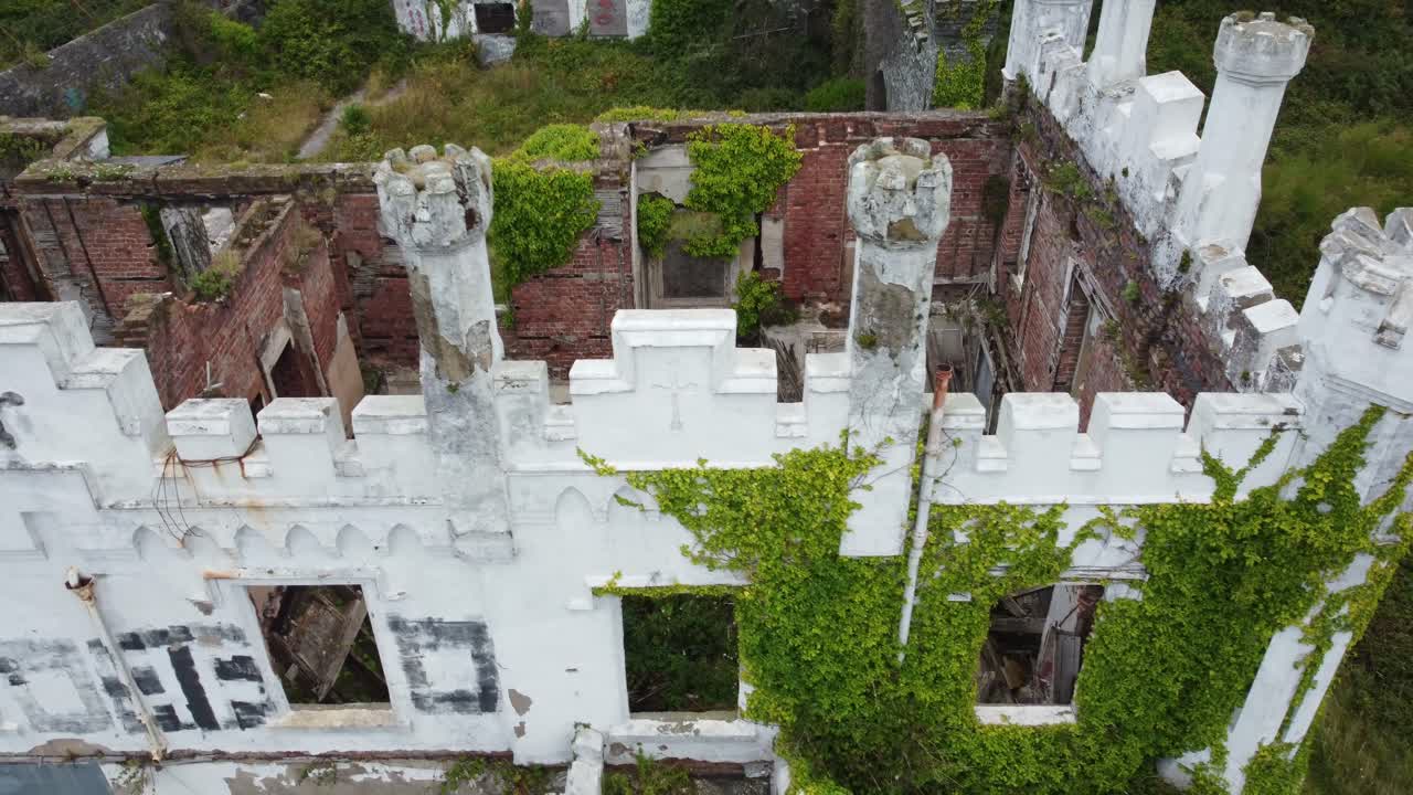 Soldiers point house aerial view looking down over ruins of abandoned white castle hotel mansion