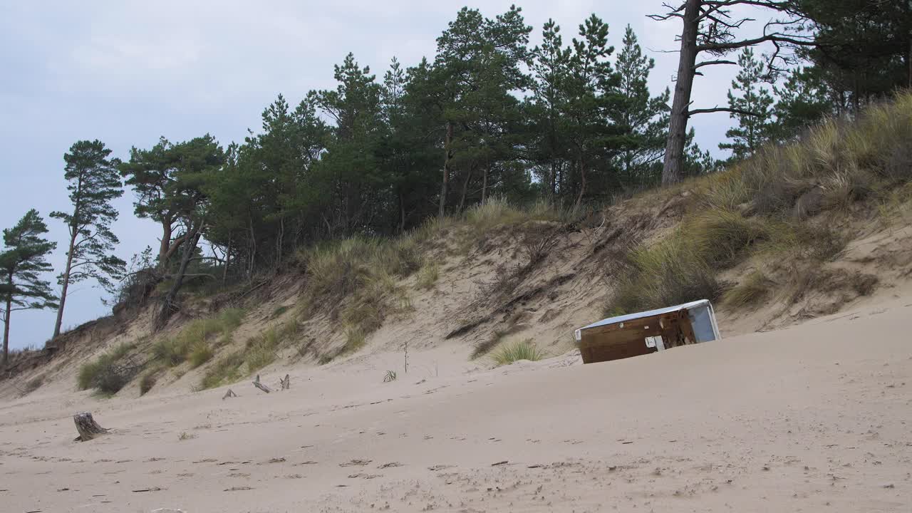 viejo refrigerador blanco en la playa, basura y desperdicios en una playa vacía de arena blanca del mar báltico, problema de contaminación ambiental, día nublado, plano general