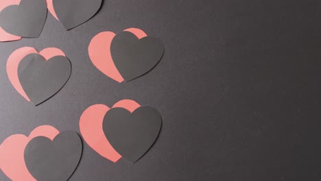 video of red and black paper heart shapes on black background with copy space