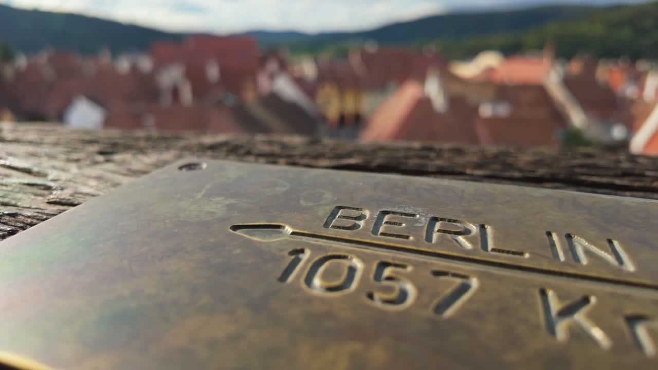 Close-up of a metal plate indicating the distance to Berlin, Germany from the Clock Tower in Sighișoara, Romania