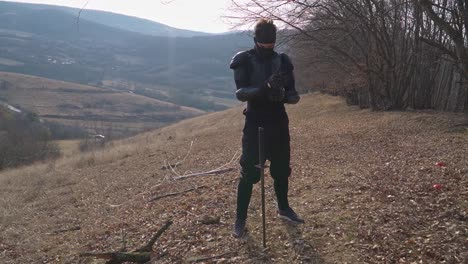 a captivating scene of a ninja with a katana on a grassy hillside, navigating dry leaves against rolling hills and valleys. ideal for adventure, travel, and wellness projects.