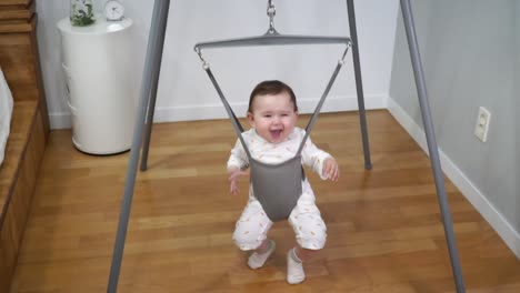 super-slow-motion of baby jumping in the special jolly jumper equipment