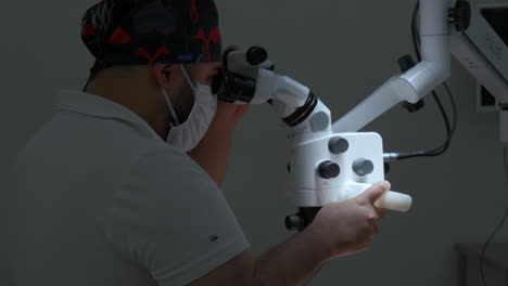 médico usando el microscopio