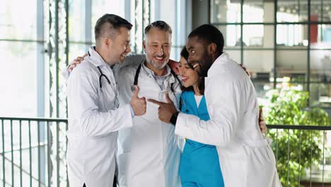 happy doctors hugging, talking and laughing