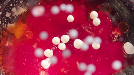 abstract white cells moving on a bright red liquid texture background