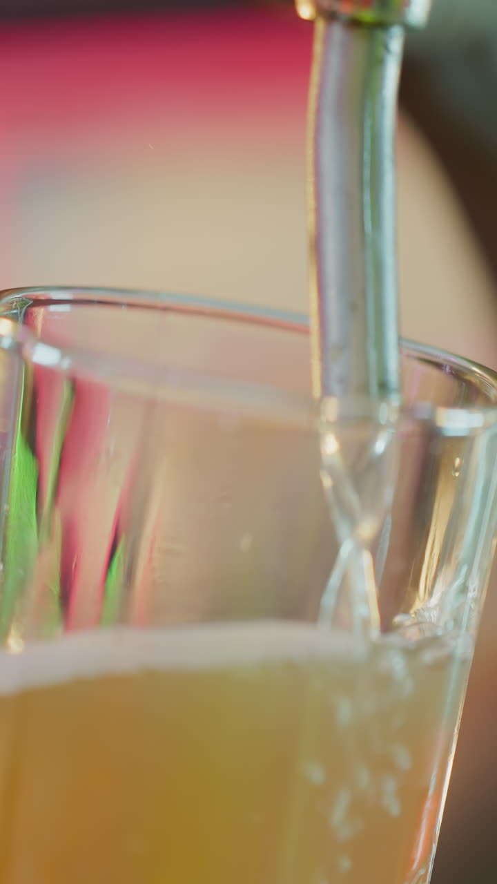 cerveza ligera vertida en un vaso en un pub de primer plano. el camarero negro llena la taza con cerveza espumosa del grifo en el bar. el barman hábil trabaja con la bebida en el club