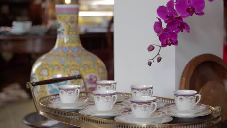 fancy english tea set with orchid in foreground