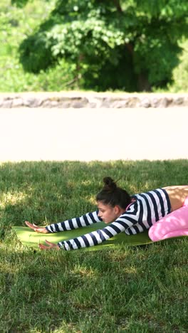 young woman doing yoga in a park