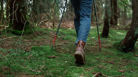 Man-in-hiking-boots-walking-on-moss-in-forest.-Male-hiker-trekking-in-woods