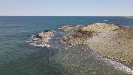 Static-shot-of-waves-crashing-onto-a-rocky-beach-along-the-Atlantic-coast,-in-Hull,-MA-USA