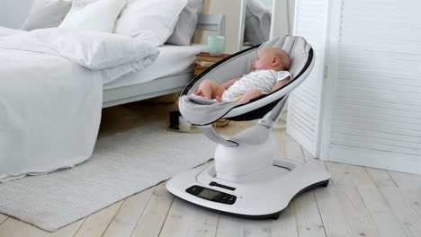 baby sleeps in a rocking chair for children high-tech design in white bedroom