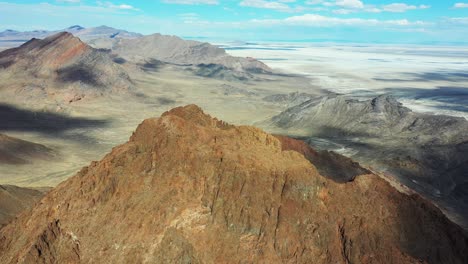 aerial view of steep rocky hills above bonneville salt flats, utah usa on sunny day, drone shot