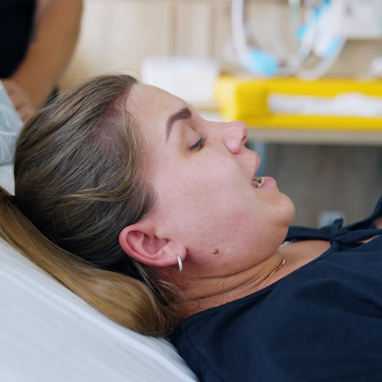 Caucasian woman delivering a baby. Lady is trying to push her child and her face becomes red. Close up