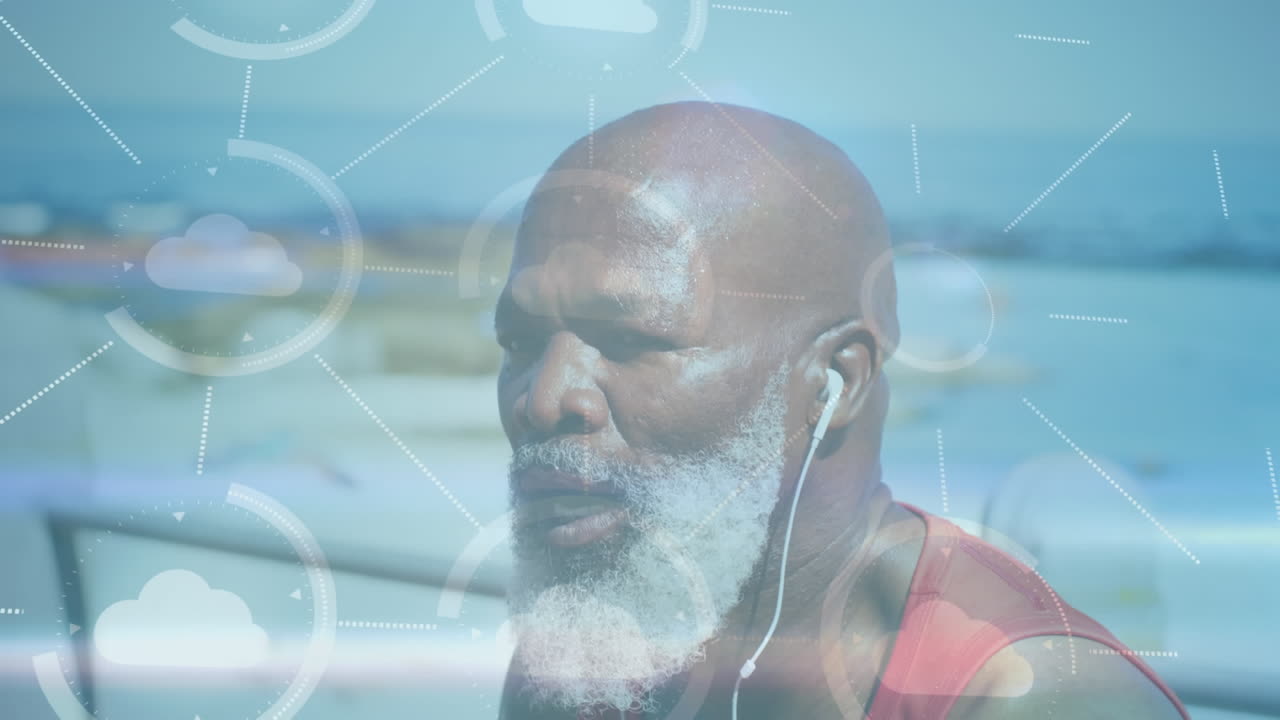 Animation of media icons over senior african american man with earphones at beach