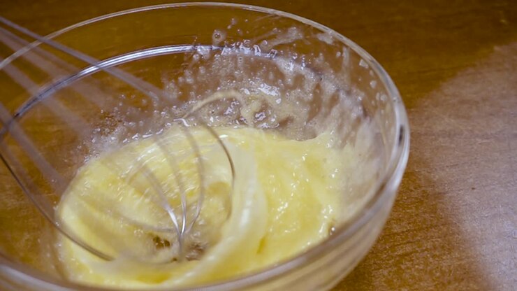 Whipped eggs with a mixer. Slow motion with rotation tracking shot.