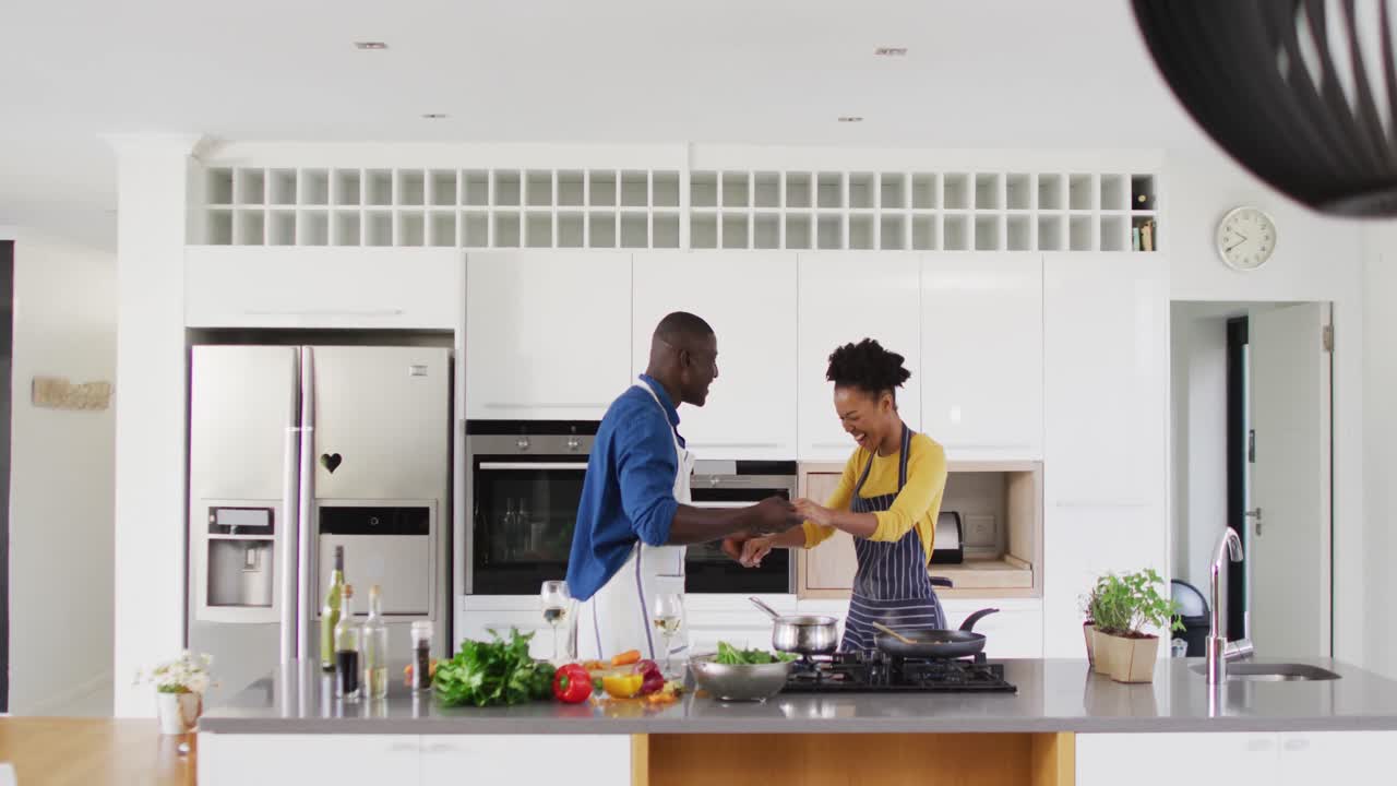 Video di una felice coppia afroamericana che balla in cucina