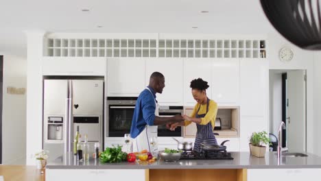 video of happy african american couple dancing in kitchen