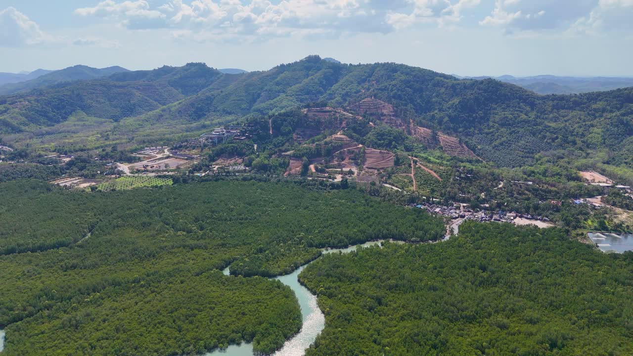 드론 영상은 태국 나가의 울창한 초록색과 휘어지는 강을 포착하여 은 하늘 아래의 활기찬 풍경을 보여줍니다.