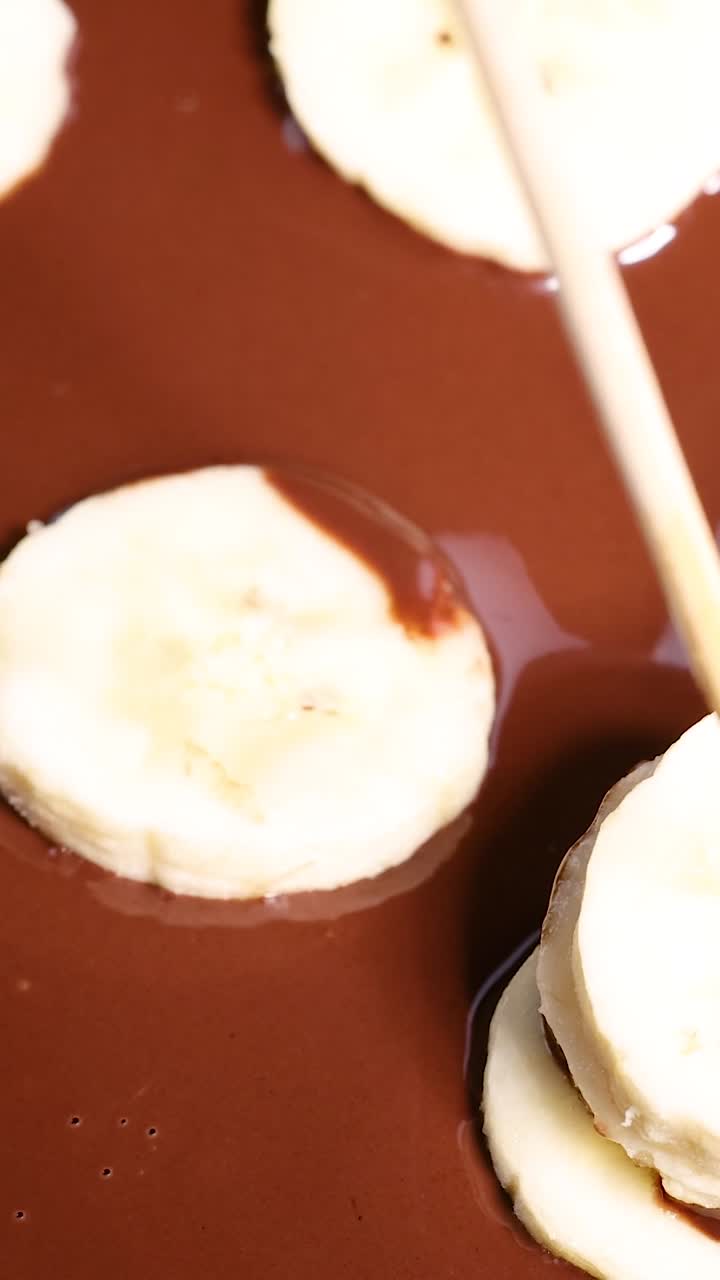 sumergir rebanadas de plátano en chocolate