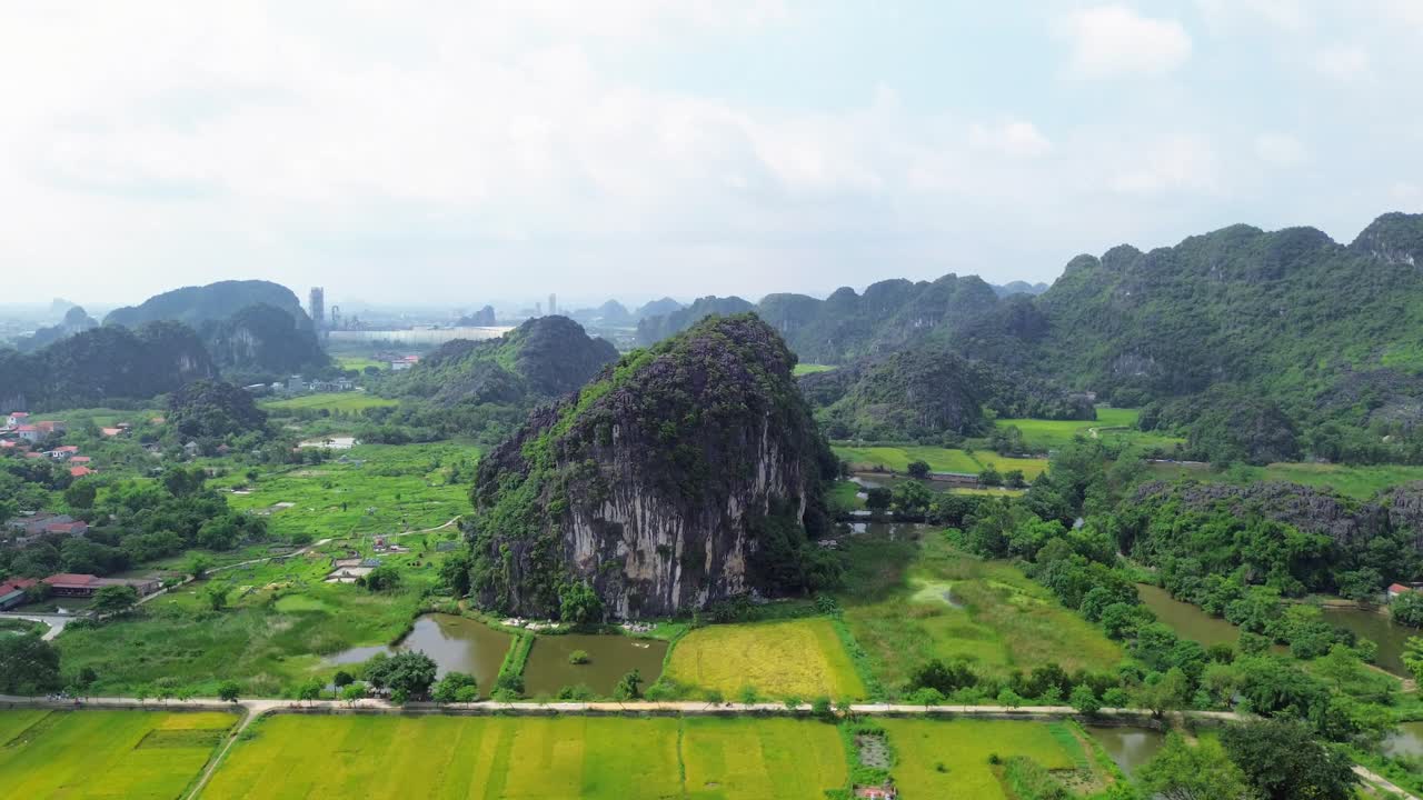 Drone semi orbit capturing sharp limestone formation rising from flat agricultural land