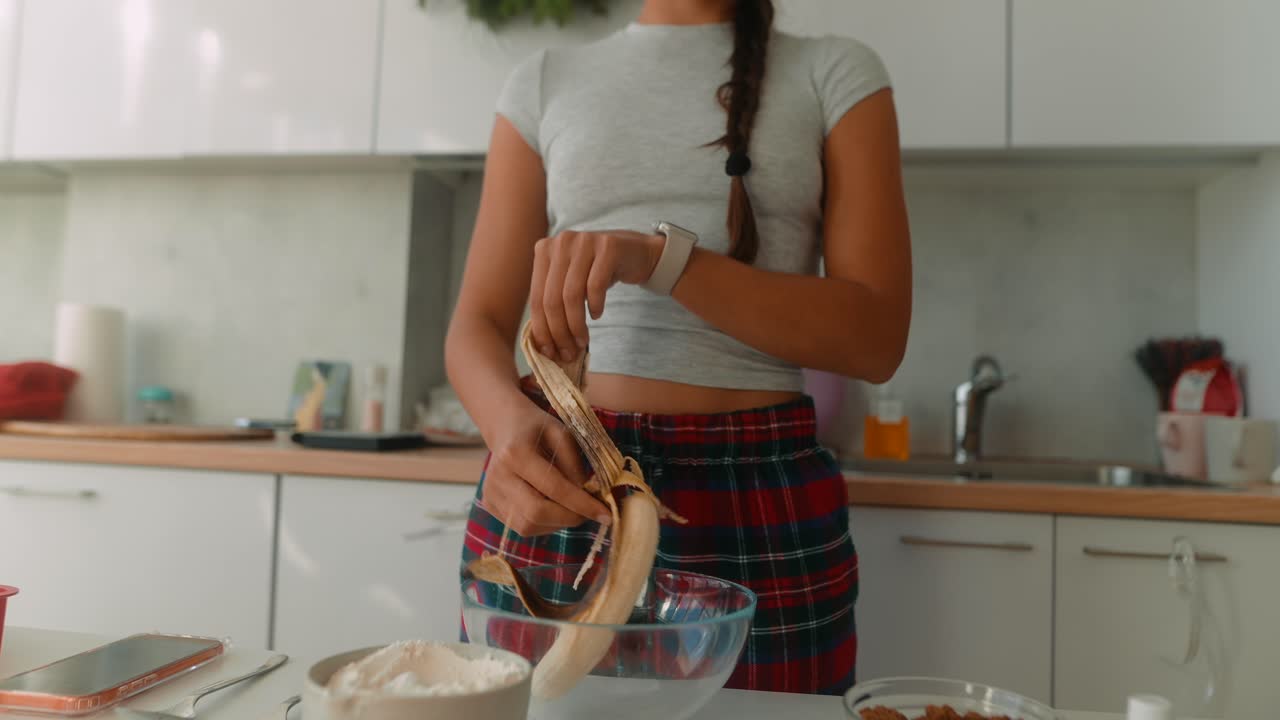 Woman preparing food in the kitchen with a banana