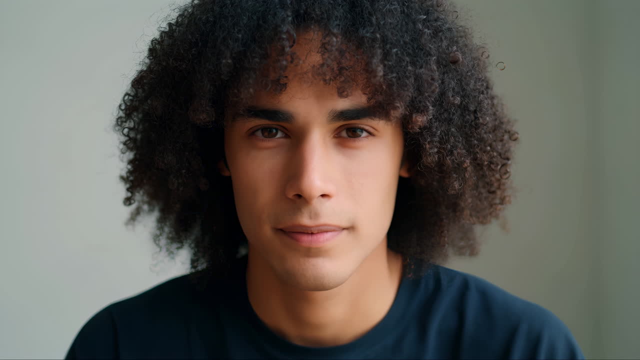 Retrato em Close-up de Jovem com Cabelos Cacheados Olhando para a Câmera.