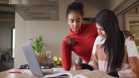 video of focused biracial women working from home with laptop