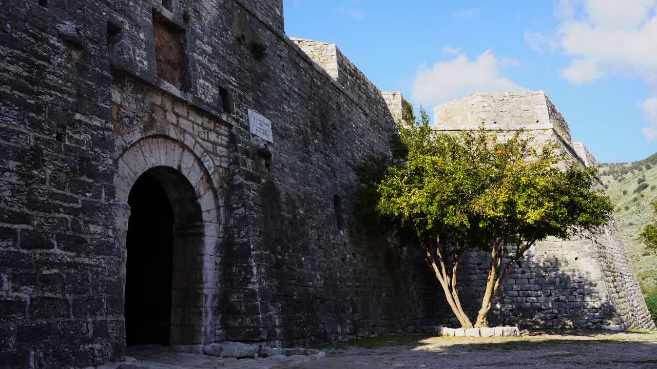 puerta arqueada de fortaleza medieval con paredes de piedra en la costa mediterránea de albania