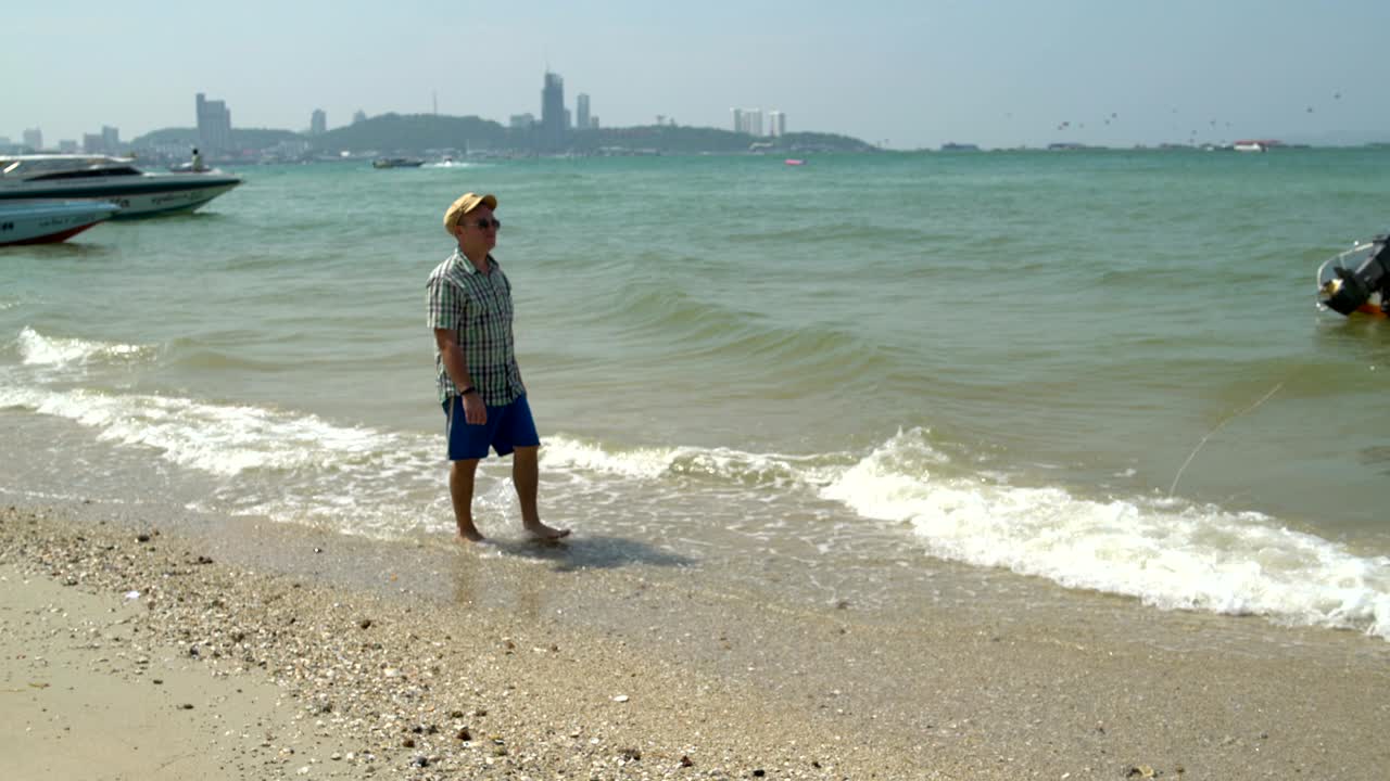 un hombre está caminando a lo largo de la orilla del mar. en el mar en las olas barcas oscilantes