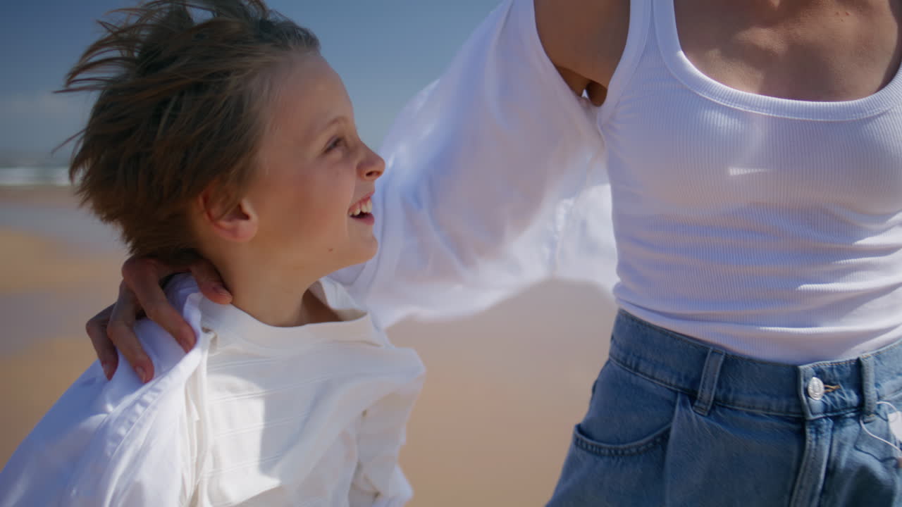 Smiling boy bonding mother sharing joyful moment on sunny beach closeup