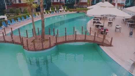 luxury hotel pool with wooden bridge