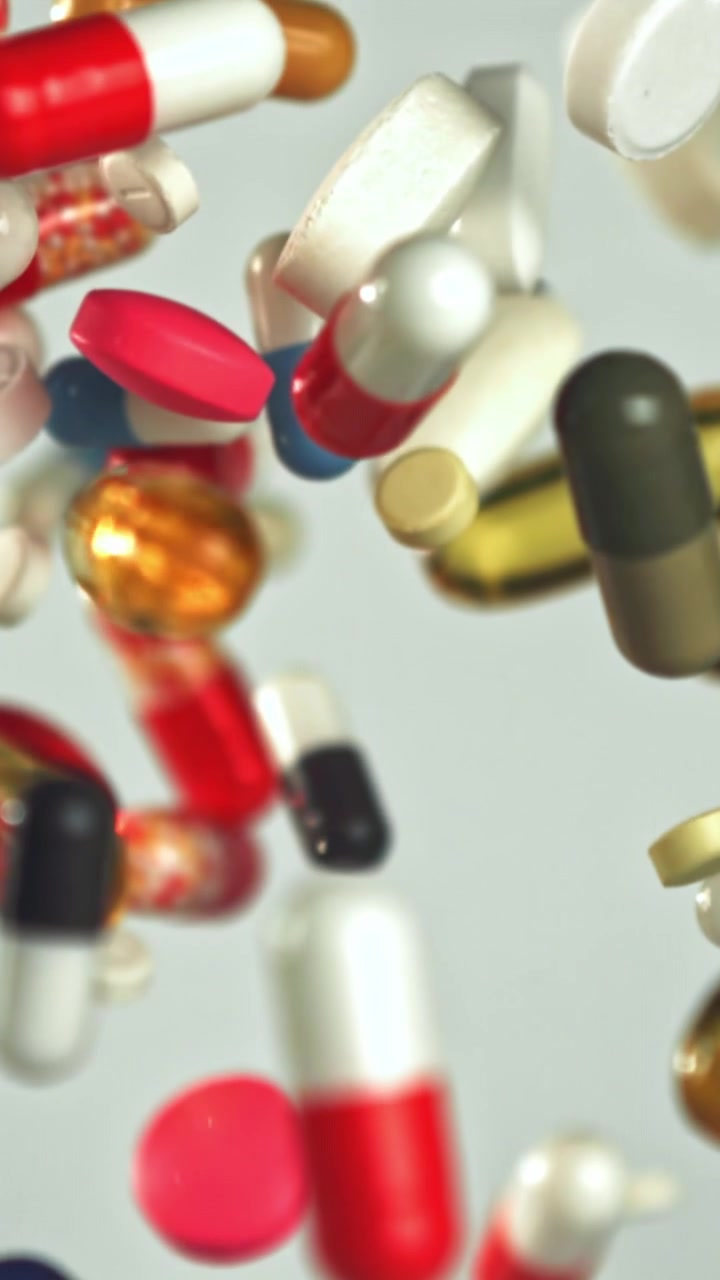 Colorful Pills and Capsules Falling in Slow Motion