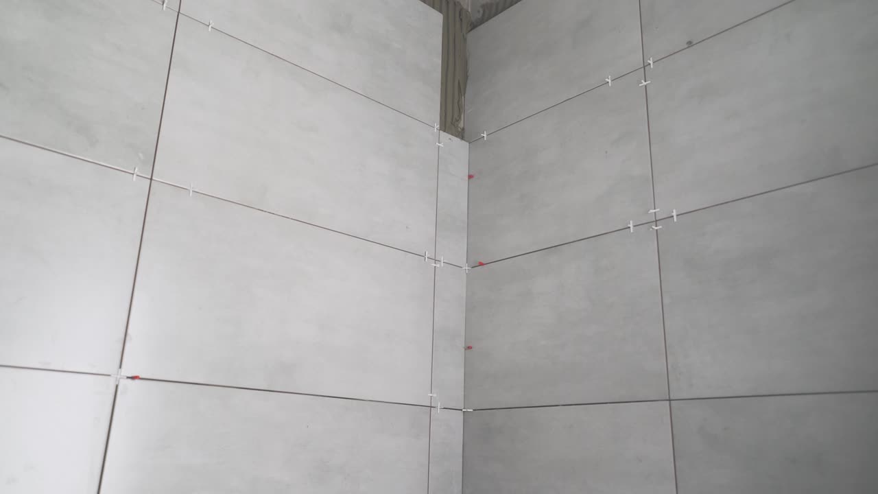 paredes de azulejos. las baldosas están pegadas a la pared. la pared del baño está azulejada con baldosas de cerámica gris.