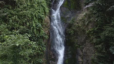 tilt down shot of a beautiful waterfall hidden in the tropical rainforest jungle in thailand
