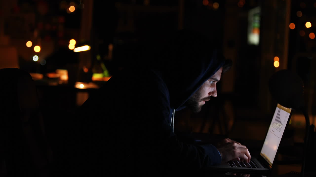 Hacker using laptop at night