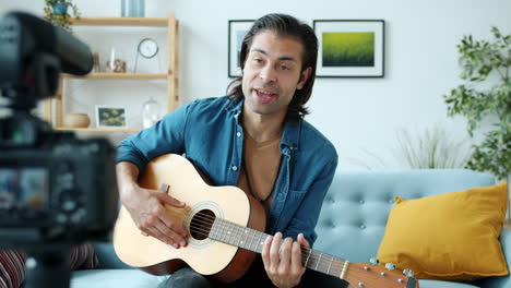 man playing acoustic guitar on camera