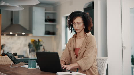 mujer trabajando desde casa en una computadora portátil en la cocina
