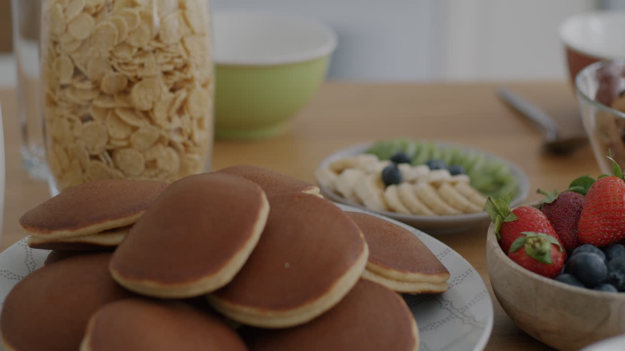 Breakfast spread with pancakes, cereal, fruit, and cookies