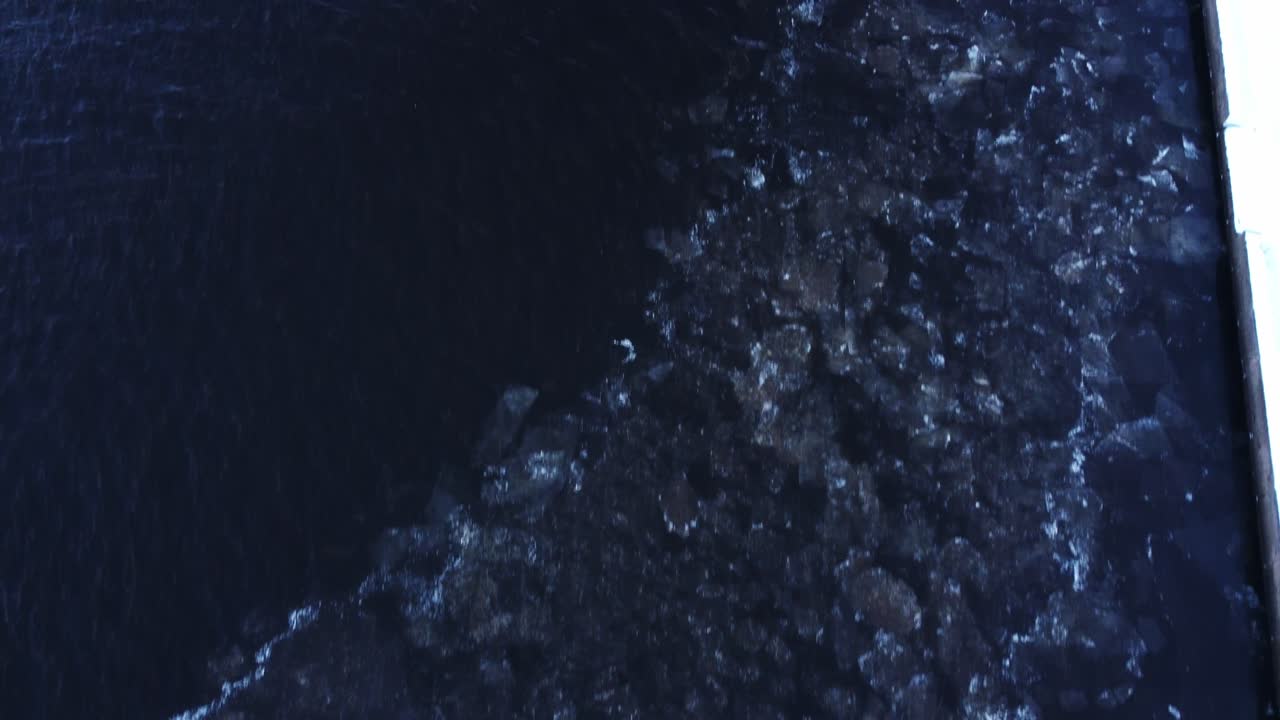 겨울철 얼음과 눈이 있는 바위투성이의 바다 해안선, 공중 드론 전망