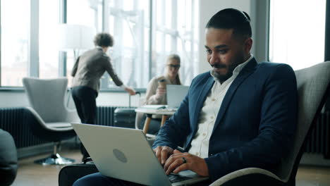 businessman working on laptop in an airport lounge