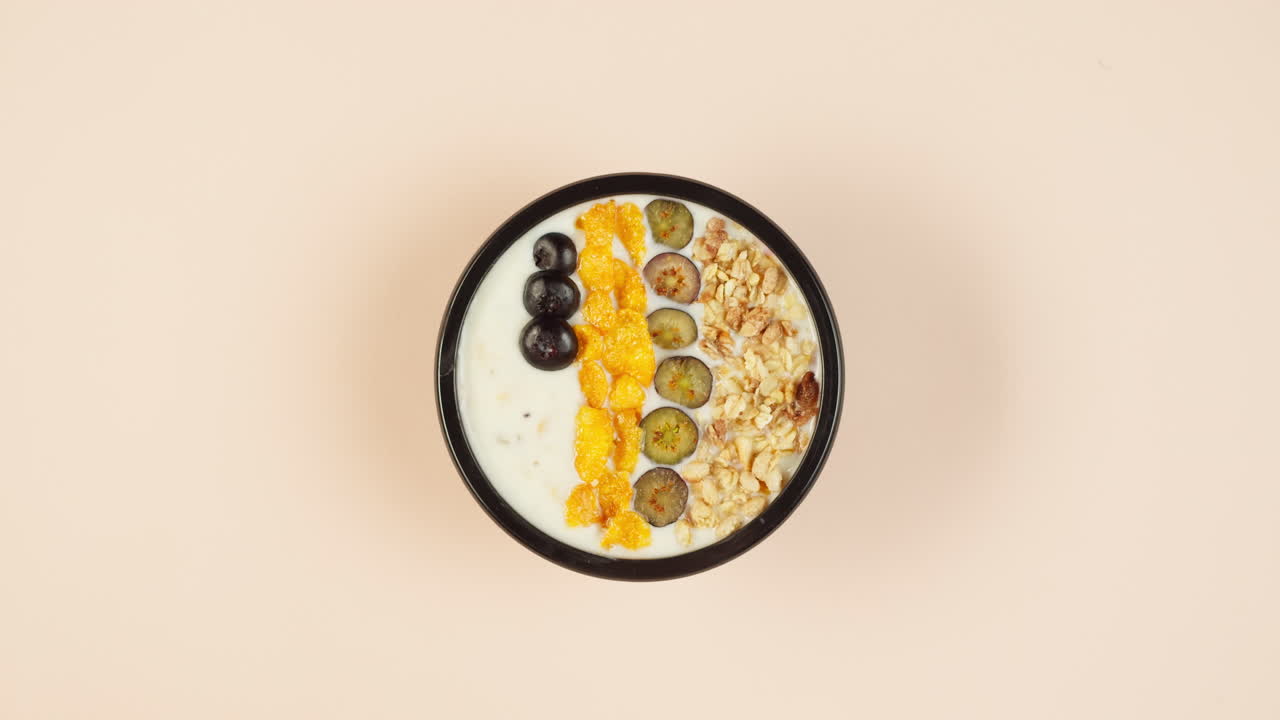 Preparazione di una ciotola per la colazione sana con mirtilli e cereali.
