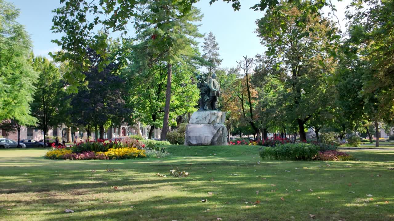 Deák Ferenc statue in Szechenyi Square, Szeged, surrounded by lush greenery