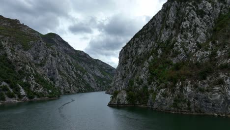 dramatic sky over komani lake with rocky landscapes and narrow valley in kukes, albania. wide drone shot