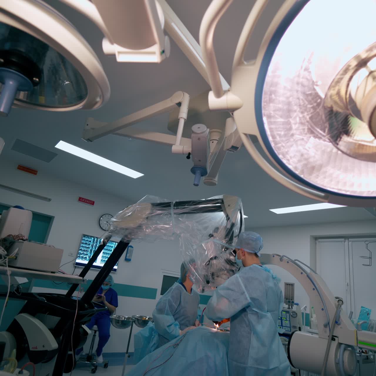 Neurosurgical process in hospital. Contemporary medical equipment in the operating theater. Medical team performing a surgery through the microscope.