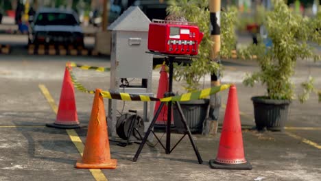 An-air-quality-checking-device-installed-outside-the-room-and-surrounded-by-warning-sign-tape