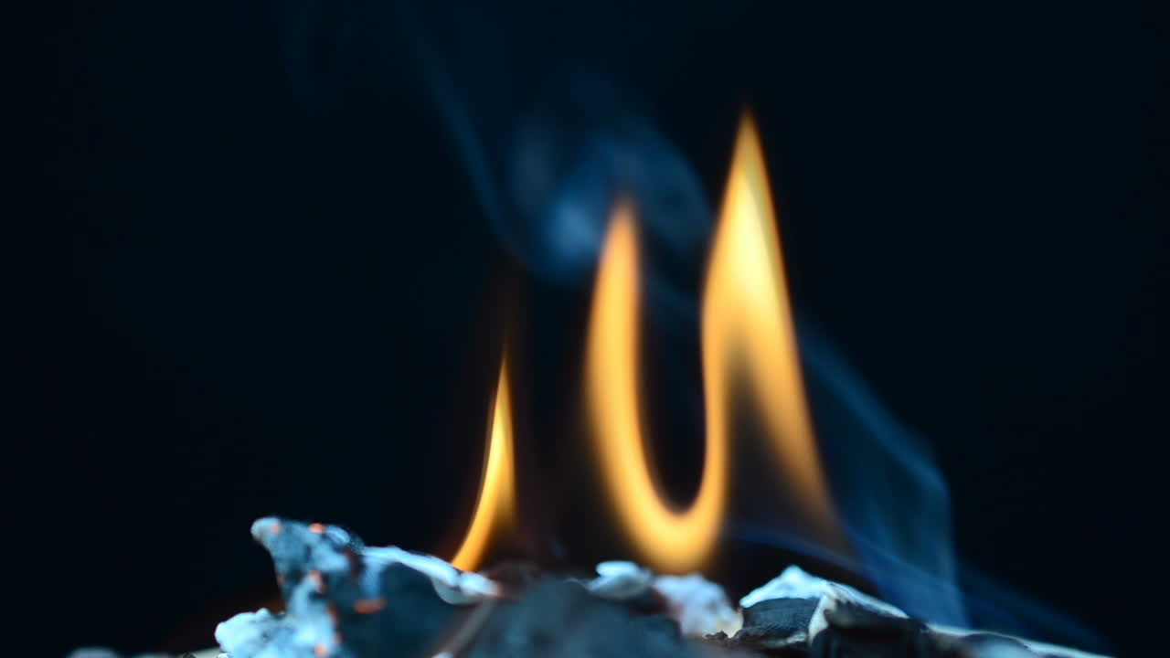 Slow Motion. The burning fabric on a black background. Slow Motion. The burning fabric