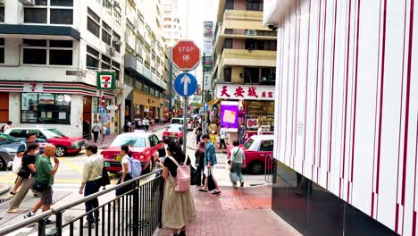 pedestrians and taxis in bustling hong kong street