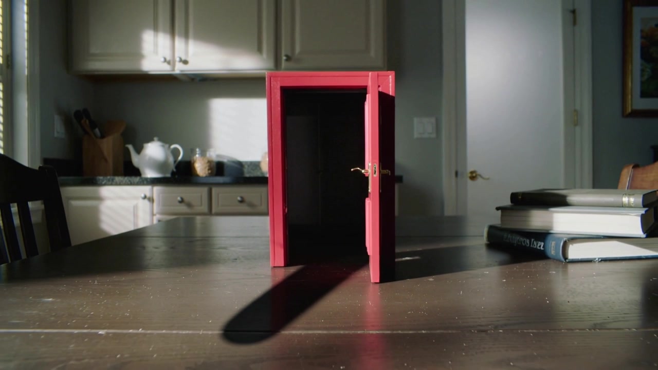 Opening red mini door starting closed, swinging outward on kitchen table, sunlight casting shadow