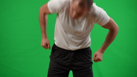 young caucasian man juggling football ball on back in slow motion catching with hands. professional young sportsman training at chromakey green screen background mockup.